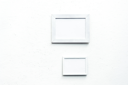 close up view of empty photo frames hanging on wall