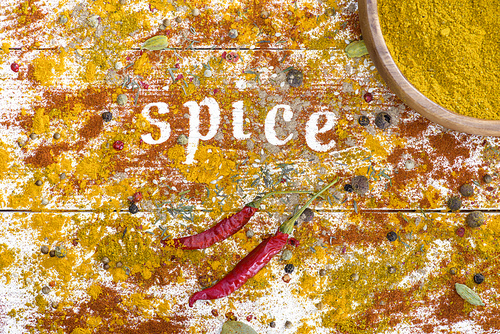 Top view on scattered spices on table and word Spice