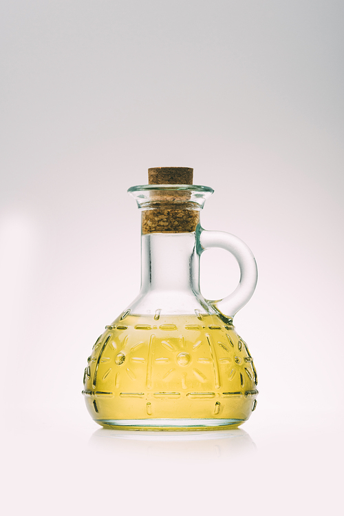 olive oil bottle on pink background