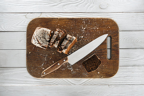 top view of sliced homemade bread and knife on wooden cutting board