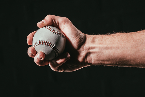cropped shot of male hand holding baseball ball isolated on black