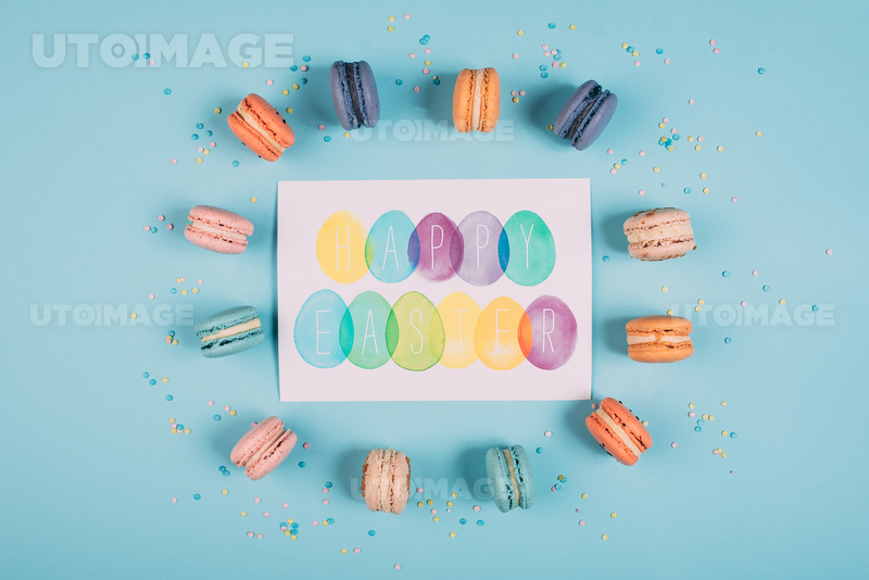 유토이미지 | top view of happy easter greeting card with colorful macarons around on blue surface