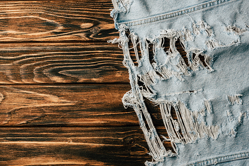 top view of light denim textile on wooden tabletop
