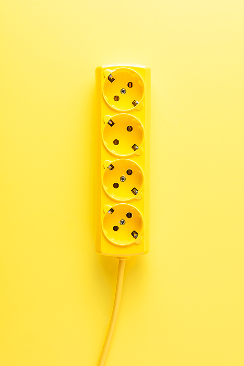 close-up view of bright yellow socket outlet on yellow background