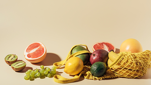 fresh ripe fruits and string bag on brown