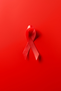 top view of aids awareness red ribbon on red background