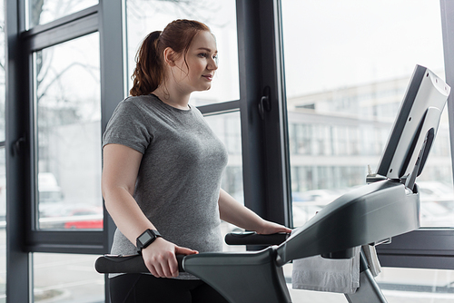 Obese girl running on treadmill in gym
