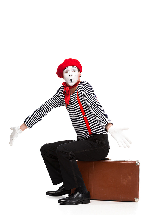 mime sitting on brown suitcase and showing shrug gesture isolated on white