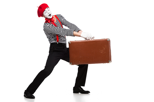 mime carrying heavy brown suitcase isolated on white