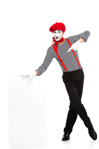 cheerful mime pointing on empty board isolated on white