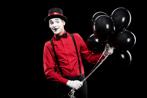 smiling mime holding bundle of black balloons isolated on black | 유토이미지 ...