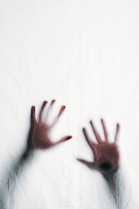 blurry silhouette of human hands touching frosted glass