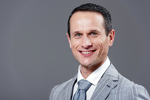 happy adult businessman in grey suit  isolated on grey