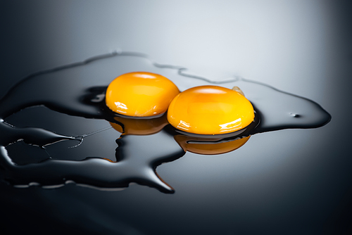 uncooked chicken yolks and proteins on black background