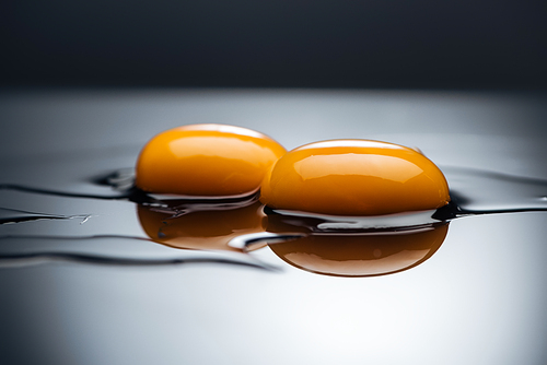 close up of raw chicken yolks and proteins isolated on black