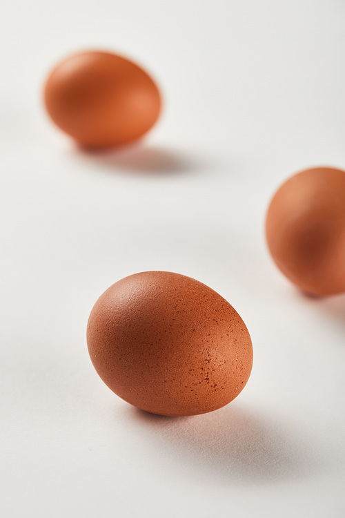 selective focus of chicken eggs on white surface