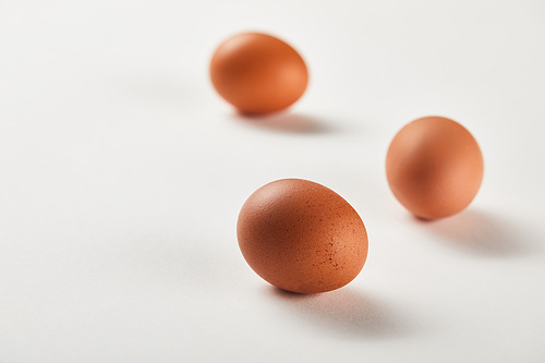 selective focus of chicken eggs on white surface