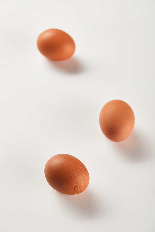 selective focus of chicken eggs on white surface