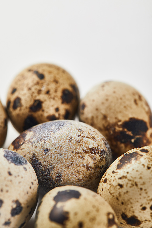 selective focus of quail eggs on white surface