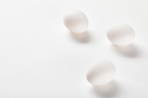 chicken eggs on white surface with copy space