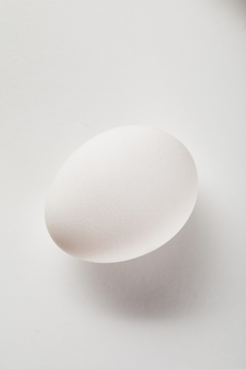 top view of chicken egg on white surface