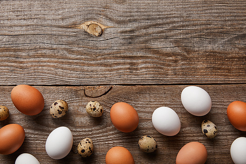 top view of quail and chicken eggs on wooden table