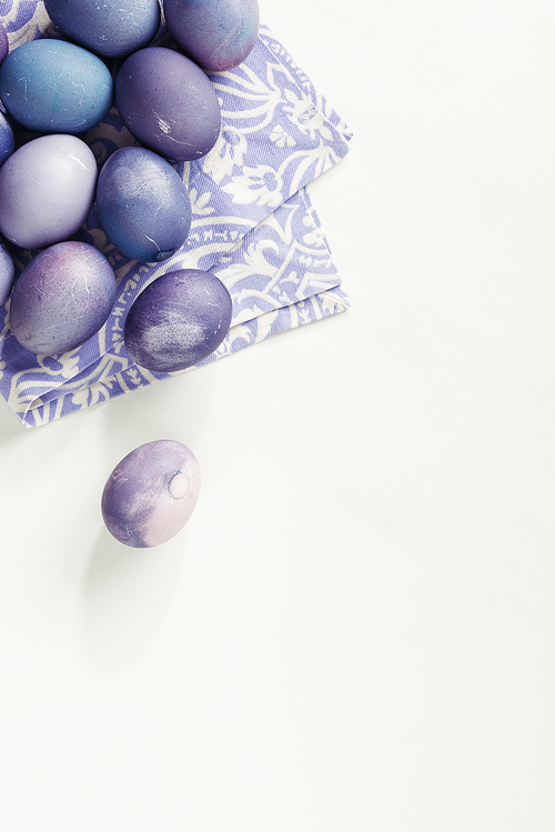 top view of purple painted easter eggs with napkin on grey