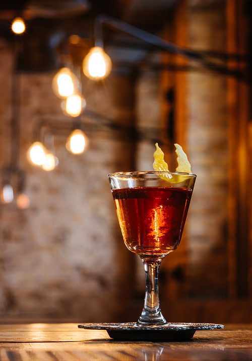 close-up view of alcoholic sazerac cocktail in glass on wooden table