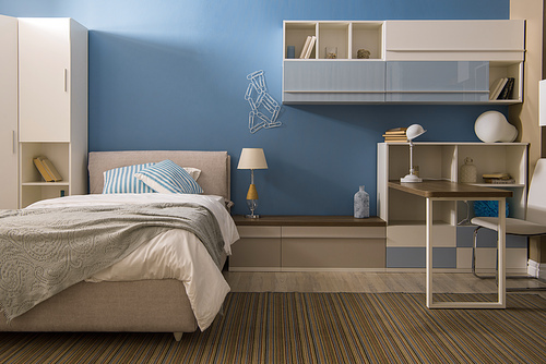 Light bedclothes on bed in cozy bedroom in blue tones