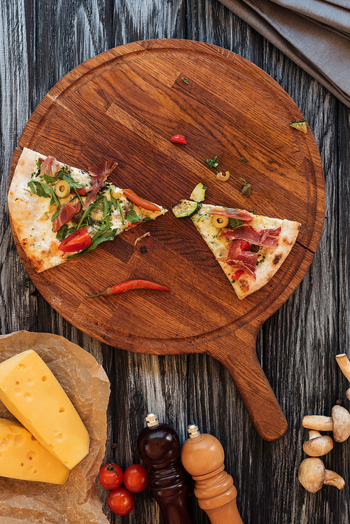 top view of slices of delicious pizza on wooden chopping board