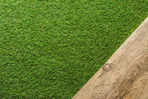 top view of green lawn and wooden plank background