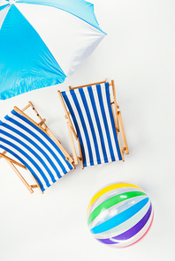 top view of beach umbrella| striped beach chairs and inflatable ball isolated on white