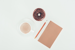top view of glazed doughnut with cup of coffee and blank kraft paper on white tabletop
