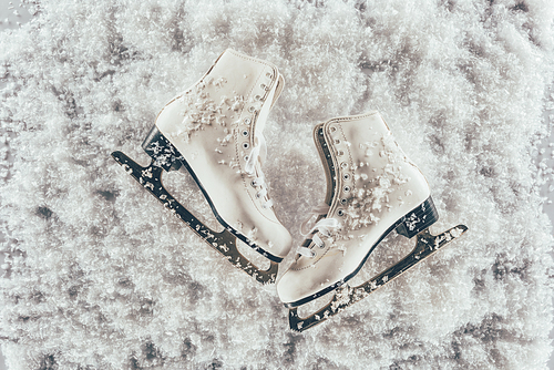 top view of pair of white skates under snow