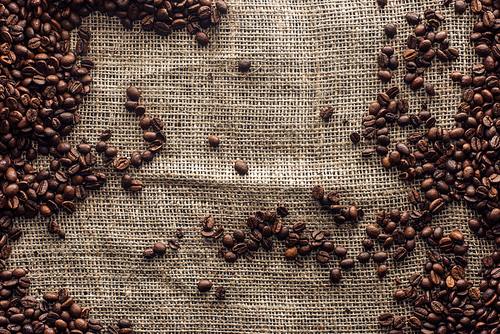 top view of roasted coffee beans on sackcloth with copy space