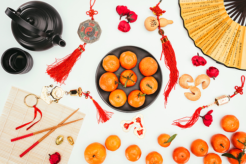 top view of various chinese talimans with tangerines and tea isolated on white| Chinese New Year concept