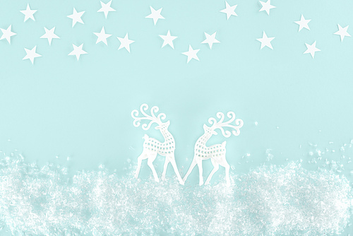 christmas background with decorative snow| stars and paper deer| isolated on light blue
