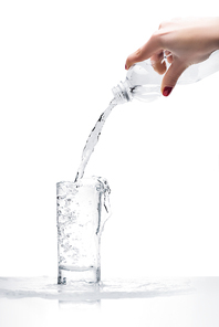 cropped shot of woman pouring water into glass from plastic bottle isolated on white
