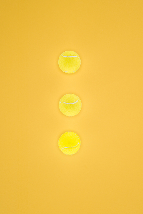 Tennis balls in a row isolated on orange background