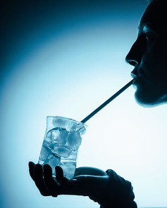 silhouette of woman drinking cold water with ice cubes with straw