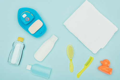 top view of baby toys and bathroom accessories scattered isolated on blue