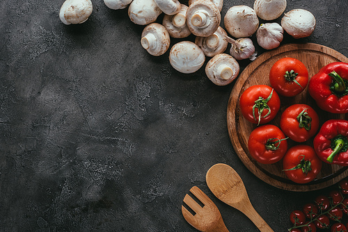 top view of raw tomatoes and mushrooms for pizza on concrete table
