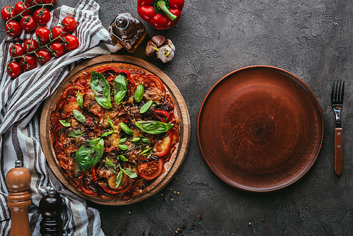 top view of delicious pizza with rustic plate on concrete table