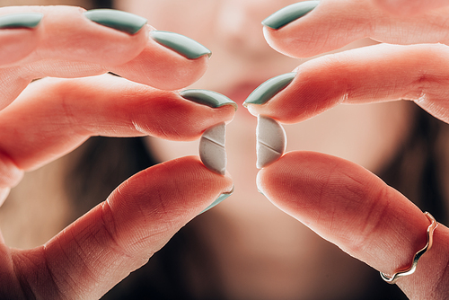 partial view of woman showing crashed pill in hands