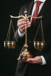 cropped shot of lawyer holding justice scales isolated on black