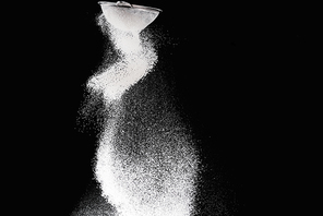 sieve with falling flour isolated on black