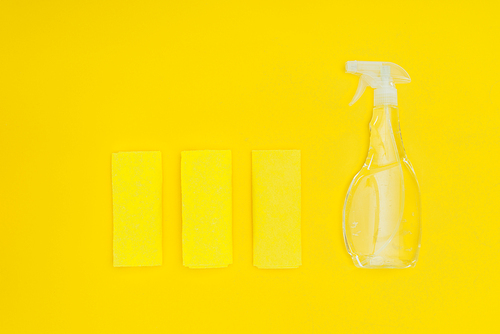 top view of rags and spray bottle isolated on yellow