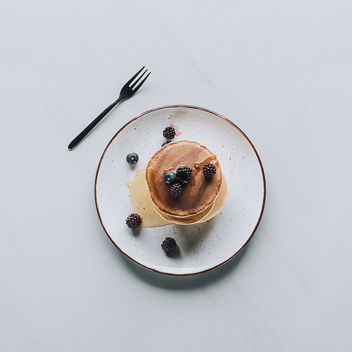 top view of sweet tasty pancakes with fresh healthy berries on grey