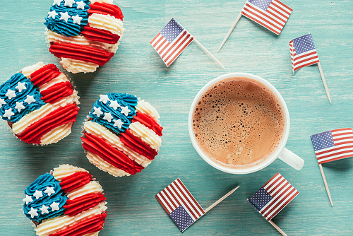 flat lay with arranged cupcakes| cup of coffee and american flags on wooden tabletop| presidents day celebration concept