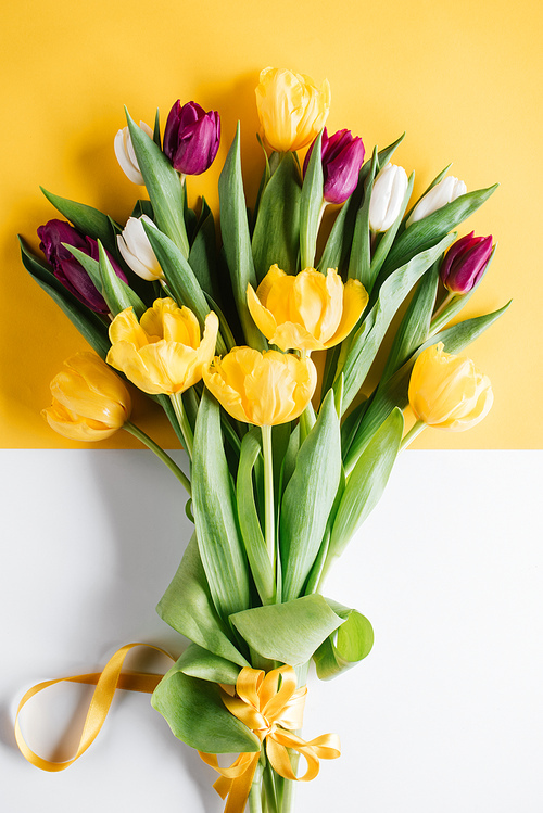 top view of yellow| pink and white tulips with ribbon for international womens day